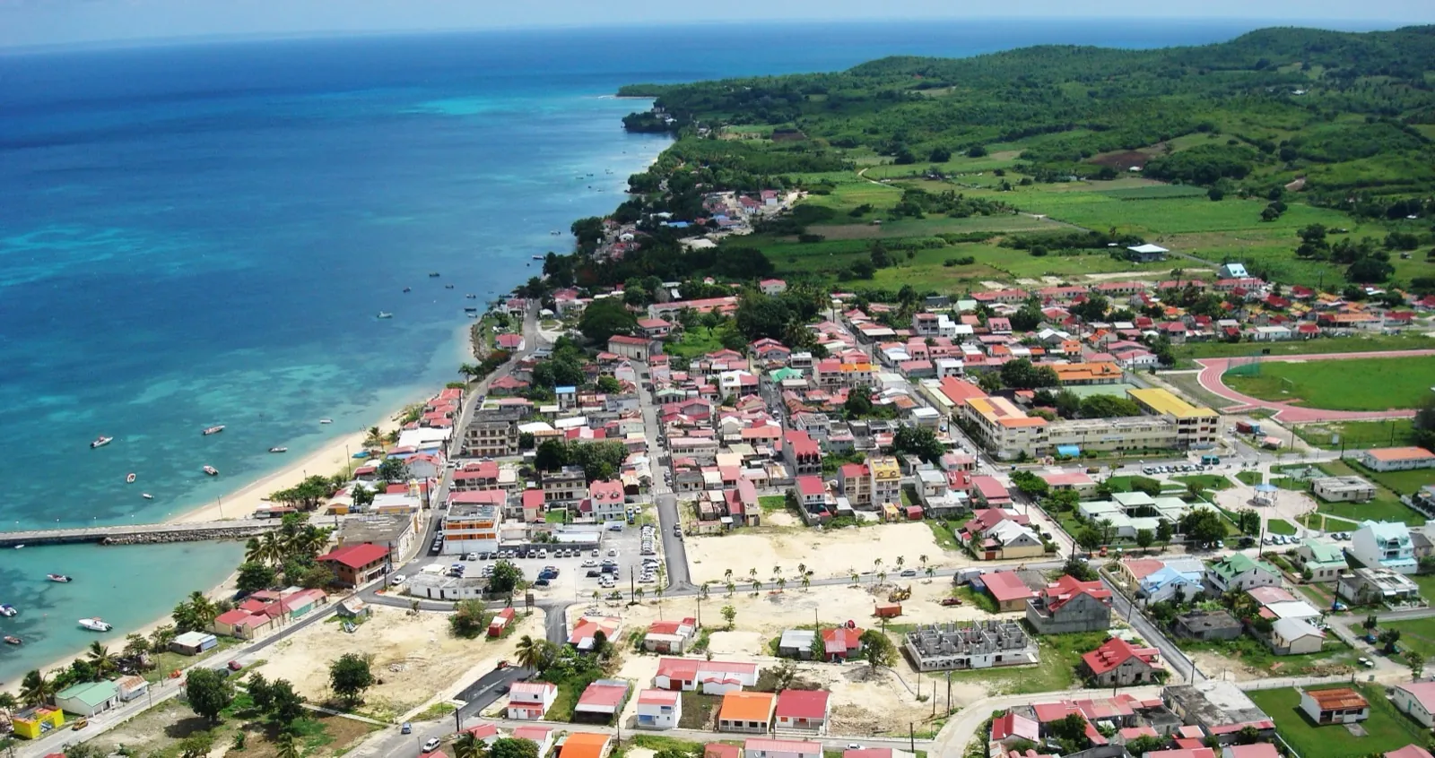 Vue aérienne du bourg de Saint-Louis, de sa plage et de son ponton, au bord d'une mer turquoise