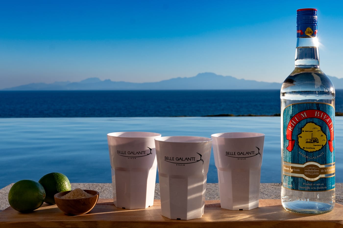 Verres de punch et bouteille de rhum face à la mer
